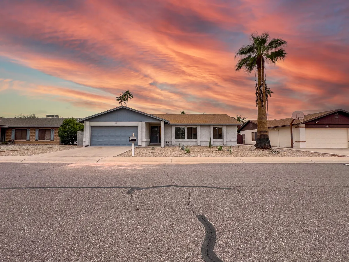 A view of a palm tree silhouetted against the sunset sky, with a front porch in the foreground. The inviting outdoor space hints at friendly gatherings, evening strolls, and a relaxed suburban lifestyle, all within reach of Chandler's attractions.